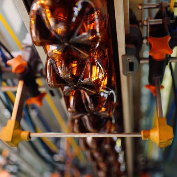 Bottled soda running through a machine.