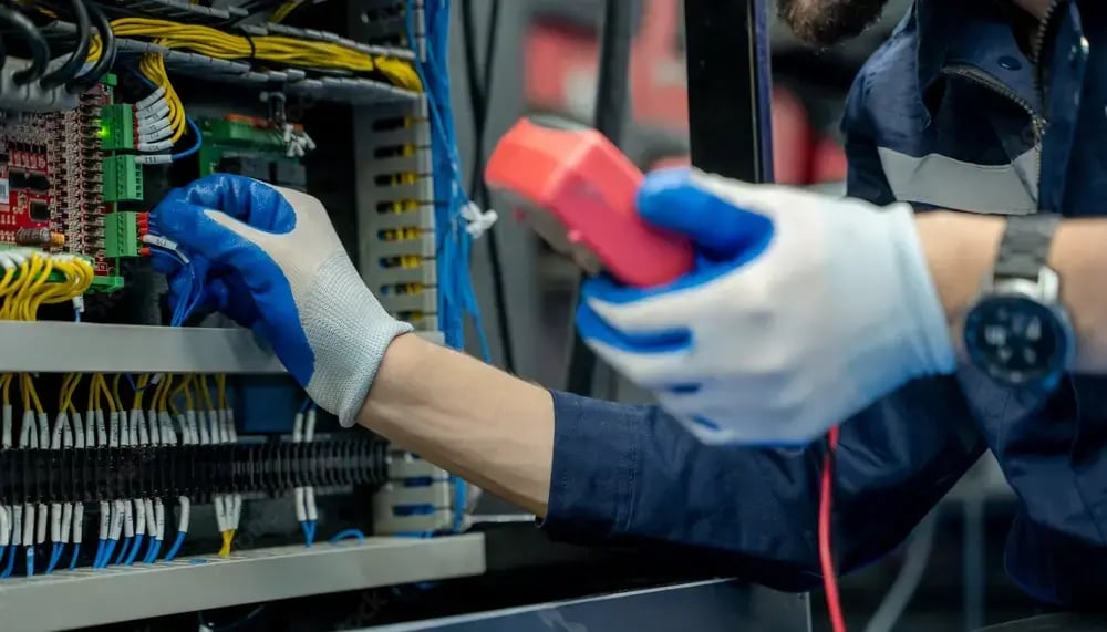 An industrial control panel  being inspected by a worker.