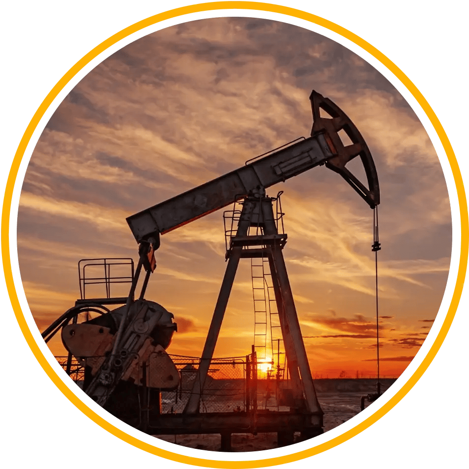 Oil well field pumpjack with sunset in background