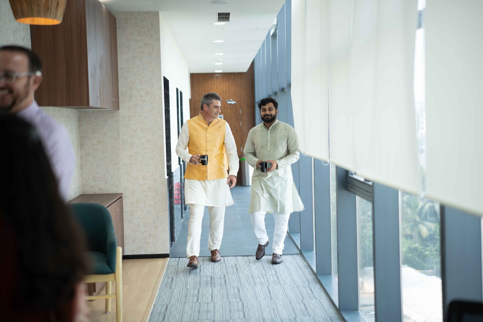 Titus and Sudeep walking down the hallway.