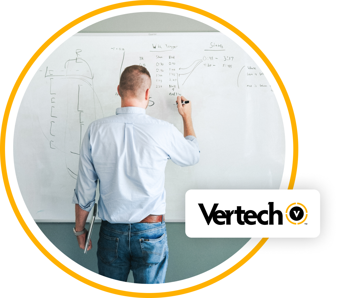 A Vertech team member draws a complex diagram on a whiteboard.
