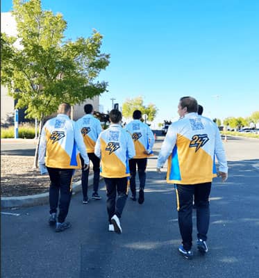 Vertech team members walking outdoors, wearing themed Esports outfits.