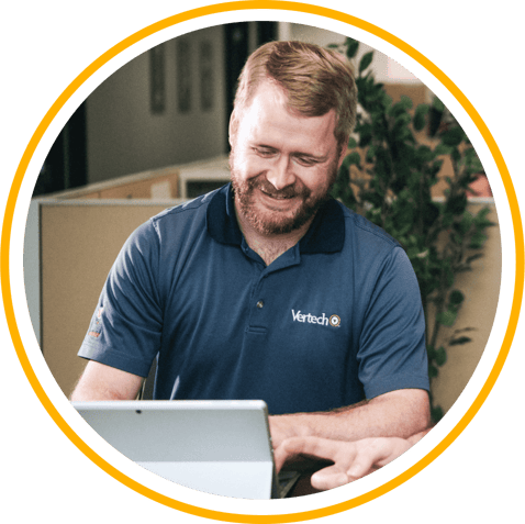 A smiling Vertech team member looks at a tablet.