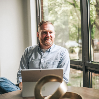 A Vertech team member with a tablet sits next to a window in the Nashville office.