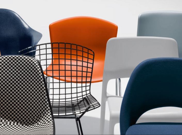 A variety of chairs in different shapes, sizes, and materials, including a plastic orange chair a wire mesh chair.