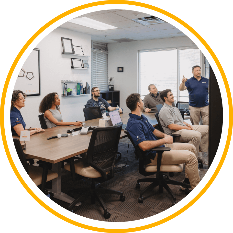 A group of Vertech team members in a conference room, engaged in discussion.