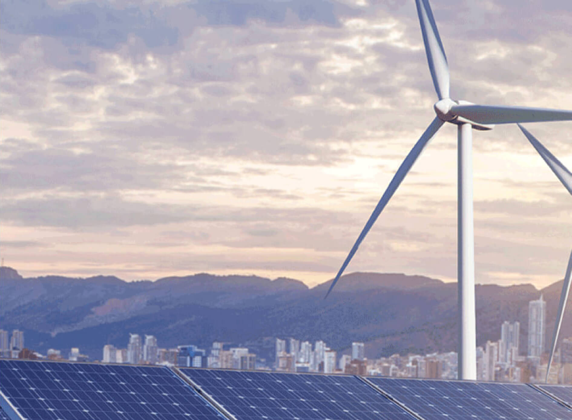 A wind turbine and solar panels with a cityscape and mountains in the background.