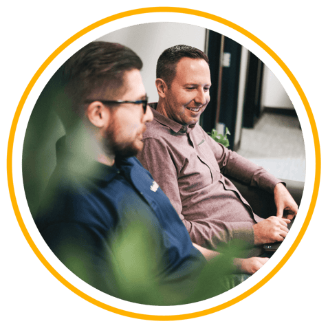 Two Vertech team members sitting next to one another, smiling.